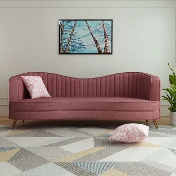 Curved channel-tufted sofa in dusty rose, styled in a living room